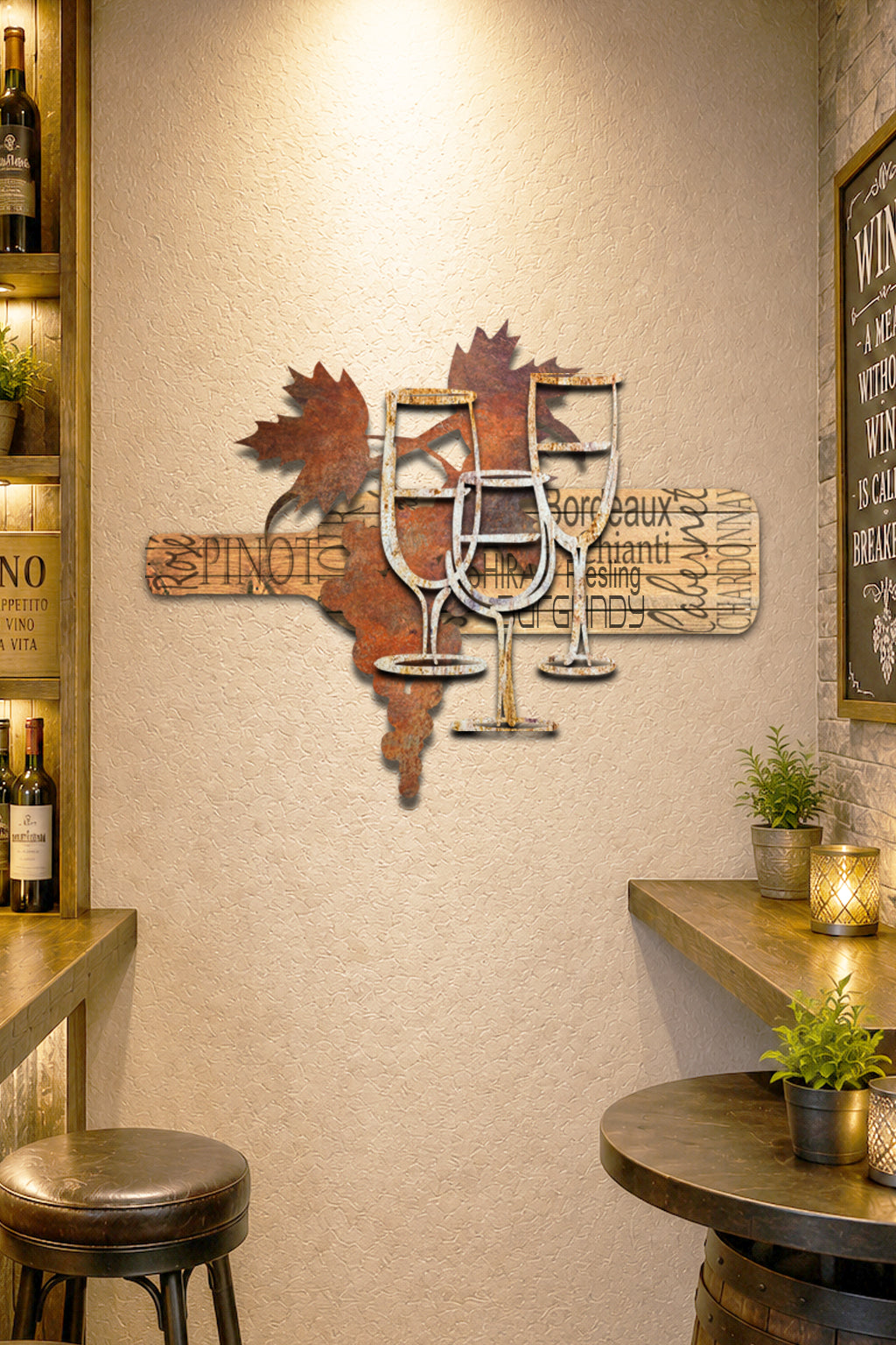 Rustic metal wall art featuring wine glasses, leaves, and a horizontal sign with wine region names like Bordeaux and Chianti, shown on a light beige background.