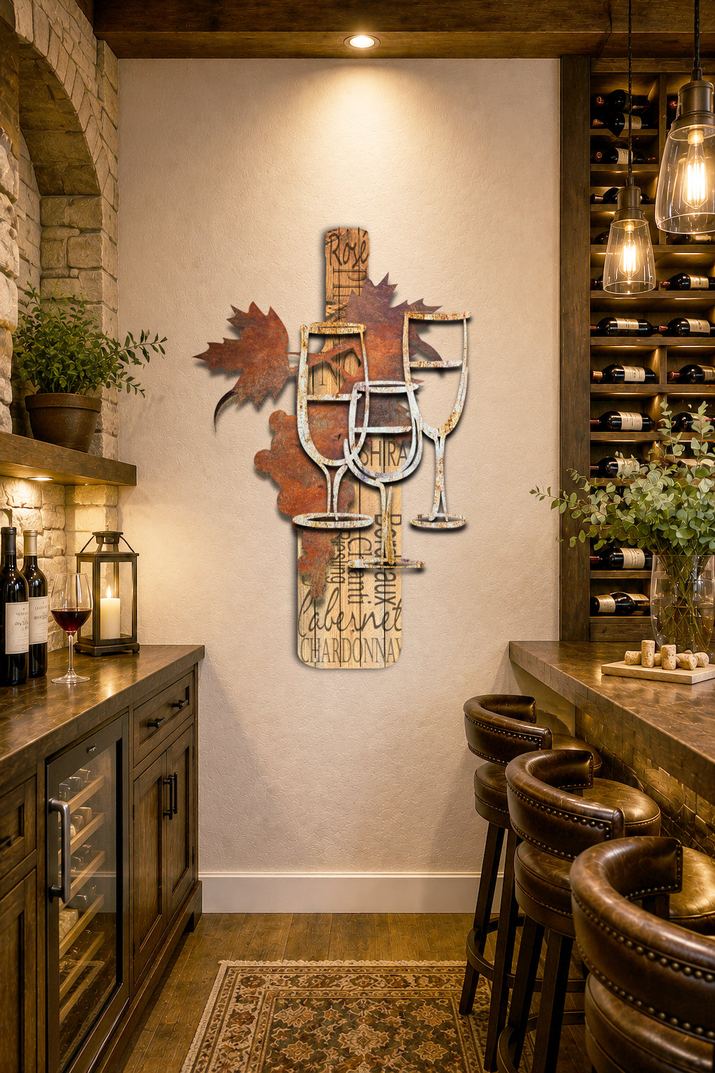 A decorative wall art piece featuring three wine glasses layered over rustic wood planks with wine-related text such as 'Rye', 'Chardonnay', 'Cabernet', and 'Shiraz', plus metal leaf accents. Handwritten text on the right reads 'Grapes and Glasses' and 'To fit those Verticle Spaces.