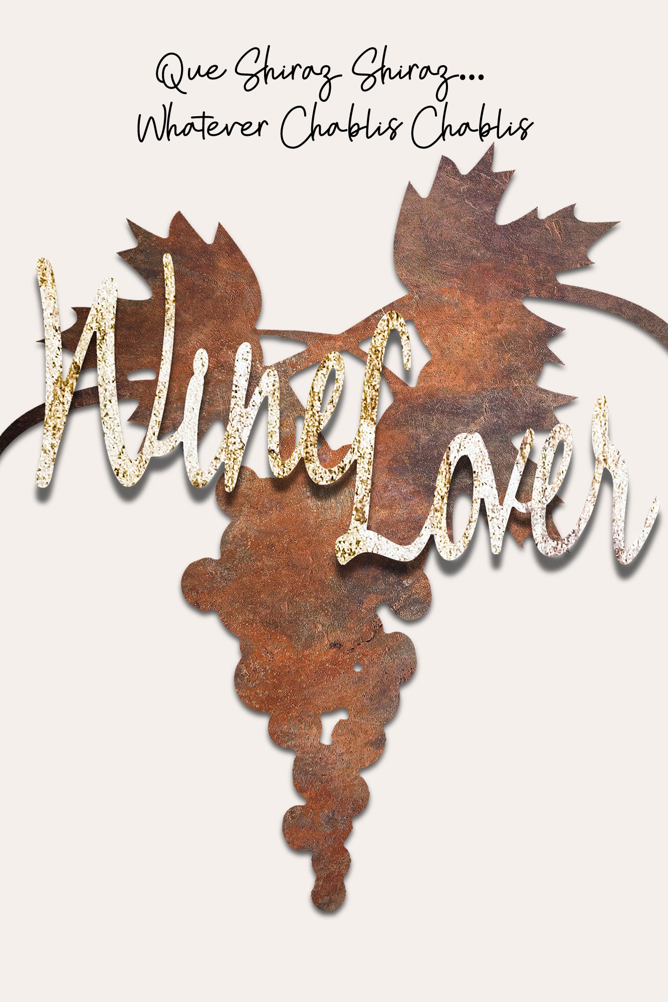 A rustic metal wine lover plaque shaped like a grapevine cluster with the words 'Wine Lover' in glittery gold and white script, set against a light beige background with the phrase 'Que Shiraz Shiraz.
