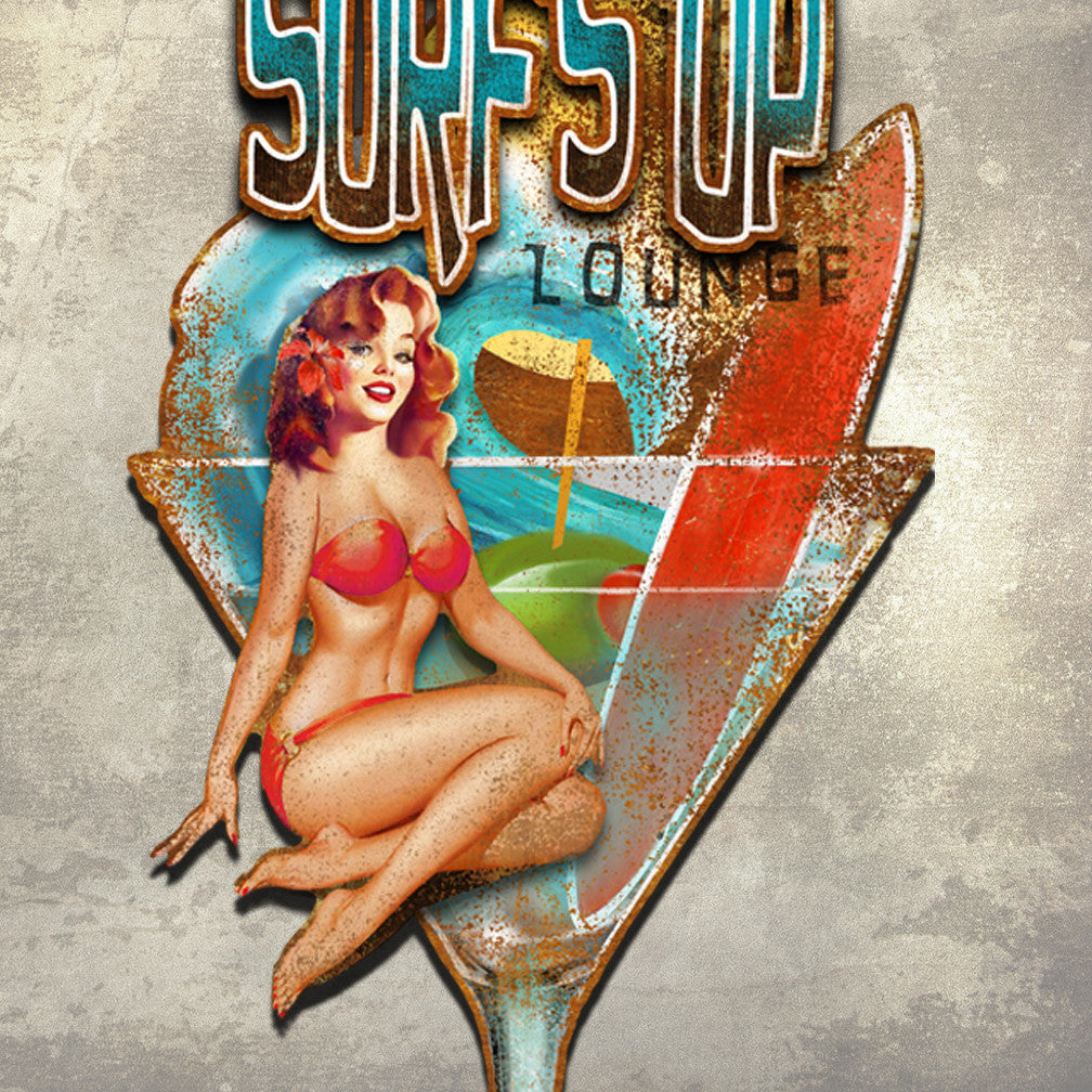 Closeup of a Metal Wall Art called Surf's Up Lounge show the background layer of a cocktail glass with an olive, wave, sun, surfboard and the word Lounge. Attached to the background are the words Surf's Up and also a pin up girl in a bikini with a flower in her hair by Ralph Burch